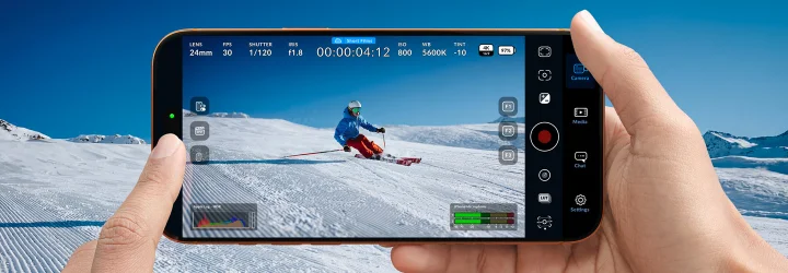 Person holding a phone with Blackmagic Camera controls open during outdoor filming