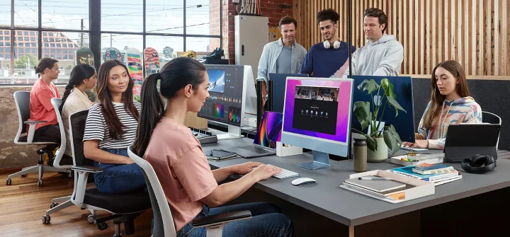 Video production team collaborating at computer workstations